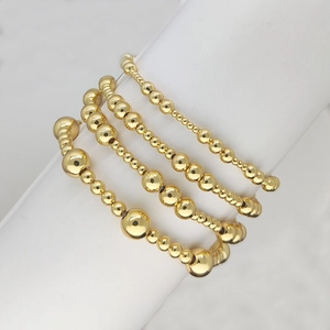 Set di 4 bracciali elastici con perline placcate oro 18K in varie misure su espositore