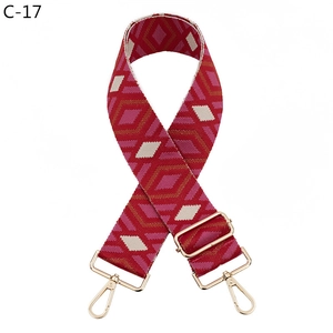 Detail of red and pink diamond pattern wide woven strap with gold metal buckles