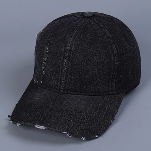 Close-up of black denim baseball cap with vintage distressed ripped details and texture