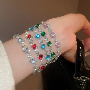 Macro detail of sparkling oval zircon bracelets in multiple colors on a female wrist