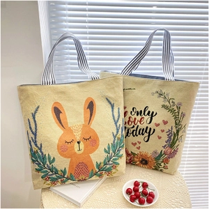 Detail of canvas tote bags featuring rabbit illustration and 'only love today' embroidery