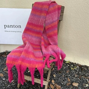 Detail shot of a thick colorful plaid scarf with long tassels on a wooden chair