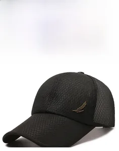 Detail view of black mesh baseball cap with golden feather emblem and extended brim