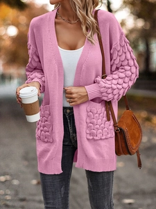 Detail of pink knit cardigan with puff textured sleeves and functional front pockets