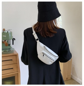 Detailed back view of a white PU leather fanny pack worn by a model in a cozy cafe