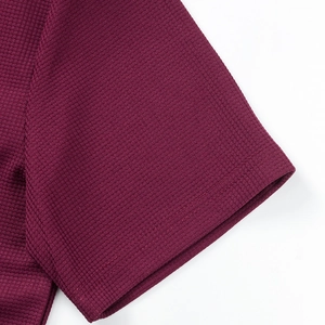 Detalle del tejido tipo gofre y costura reforzada del puño en la camisa de color burdeos
