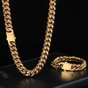 Close-up of polished gold Cuban chain necklace and bracelet set in premium black box
