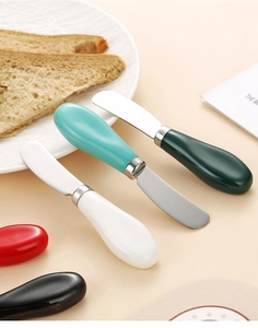 Dettaglio dei coltelli da burro in acciaio inox con manici colorati in ceramica