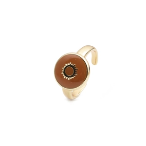 Detail of gold-plated open ring featuring a sunburst motif on a brown enamel surface