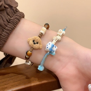 Detailed view of handmade woven bracelets with cute animal charms and natural stone beads
