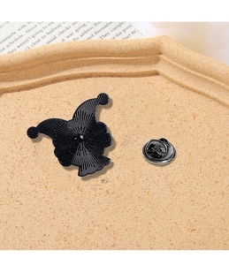 Detail of metal pin back with non-slip texture and butterfly clutch on wooden base