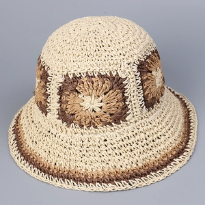 Detail of hand-woven straw hat showing beige and brown crochet flower patterns on brim