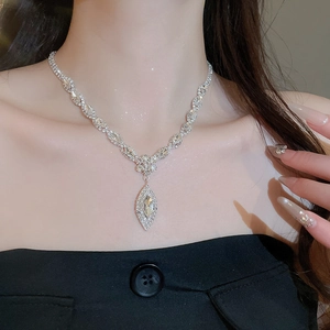 Close-up of a luxury silver water drop necklace with marquise zircons worn by a model
