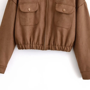 Detail of brown faux suede jacket featuring metal buttons and elastic hemline