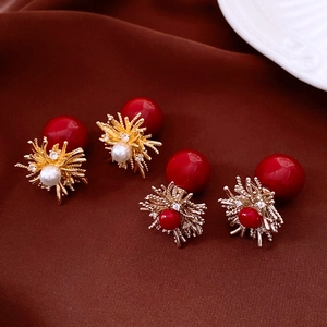 Detailed close-up of 18k gold plated flower earrings with pearls and red beads