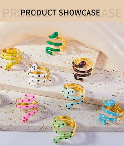 Detailed view of colorful enamel snake-shaped gold-plated wrap rings on beige stone