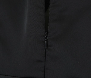 Détail en gros plan de la fermeture éclair invisible sur une robe en satin noir avec dentelle