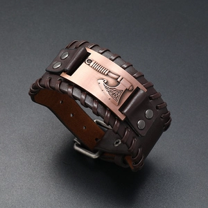Close-up of Viking axe engraving on brown braided leather bracelet with copper hardware