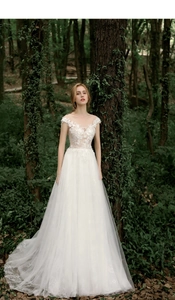 Detail of white forest style wedding dress featuring sheer lace and beaded embroidery