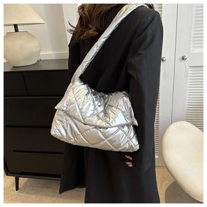 Close-up of metallic silver puffer bag showing quilted diamond pattern and plush texture