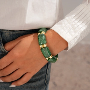 Detailed shot of retro green resin link bracelet with gold beads on model's wrist