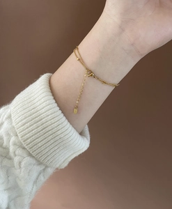 Close-up of double-layer gold square bead bracelet with lobster clasp and extension chain
