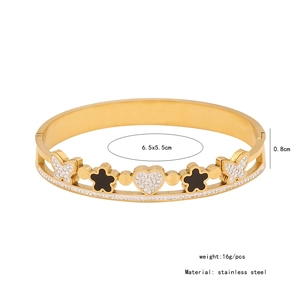 Détails d'un bracelet jonc en acier inoxydable doré avec motifs papillon fleurs et cœur
