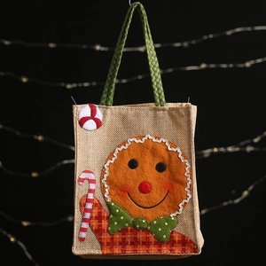 Gingerbread man burlap Christmas gift bag with festive bokeh lights background