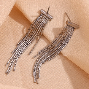 Close-up of silver tassel earrings featuring multiple fine hanging chains on fabric