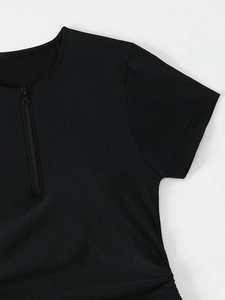 Detail view of black short-sleeve tankini top with functional half-zipper neckline