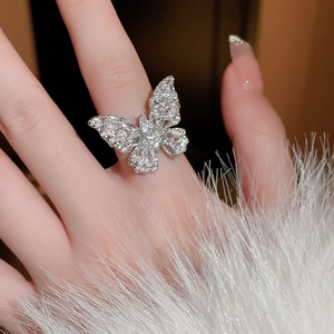 Elegante anello aperto a farfalla in zircone argento indossato da modella su pelliccia