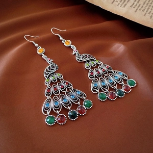 Detail of vintage peacock drop earrings with multi-color rhinestones and silver finish