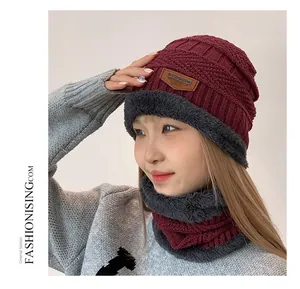 Detail view of burgundy knitted winter hat and neck warmer with thick faux fur lining
