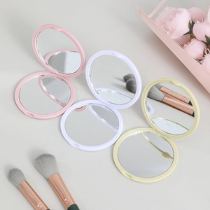 Portable folding round makeup mirrors in pink, white, and beige with floral accents