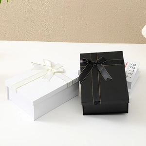 Elegant black and white foldable gift boxes with decorative ribbon bows and gold edges