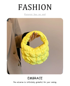 Detail of bright yellow quilted cloud bag showing bubbly texture and zipper closure