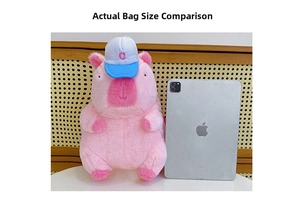 Pink plush capybara backpack with baseball cap shown next to a tablet for size comparison