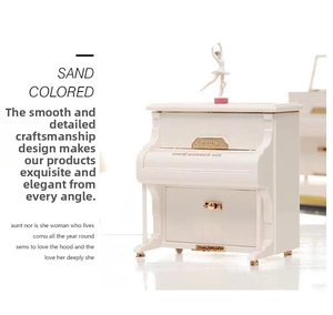 Detailed close-up of ivory piano music box featuring a spinning ballet dancer and gold trim