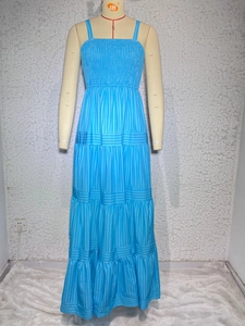 Detail of light blue tiered sun dress featuring smocked bodice and vertical stripes