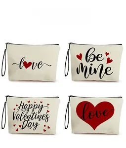 Detail view showing four canvas Valentine's Day makeup bags with love prints and wrist straps
