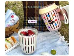 Detail showing portable pink fruit cup with strap and inner drain basket for strawberries
