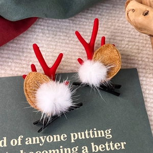 Nahaufnahme von Weihnachts-Rentier-Haarspangen mit roten Geweihen und weißen Pompons