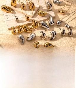 Macro detail of teardrop jewelry set in gold and steel with hammered metal texture