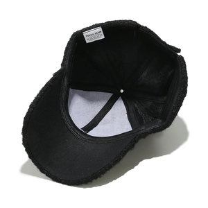 Detail view of black teddy fleece baseball cap interior showing mesh lining and label