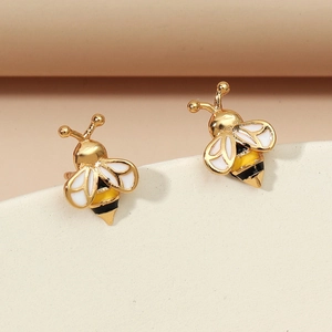 Close-up detail of golden bee stud earrings with colorful enamel wings and body texture