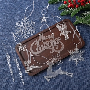Clear acrylic Christmas ornaments set with reindeer and snowflakes on wooden tray