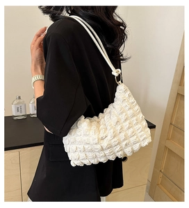 Detail showing the white bubbly texture and pleated design of the cloud-style shoulder bag