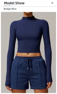 Detail of emblem blue long sleeve crop top and drawstring shorts in elastic knit fabric