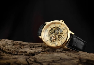 Close-up of vintage skeleton mechanical watch with gold case on aged wood