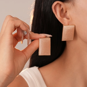 Champagne resin square earrings with gold metal frame and glitter finish on model